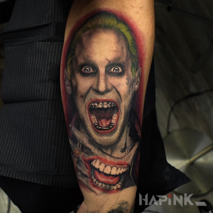 Tattoo Gangsta joker in characters motif and realistic style on the forearm