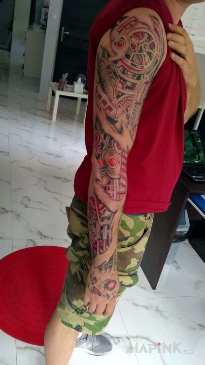 Tattoo Piti in colorful motif and biomechanics style on the forearm