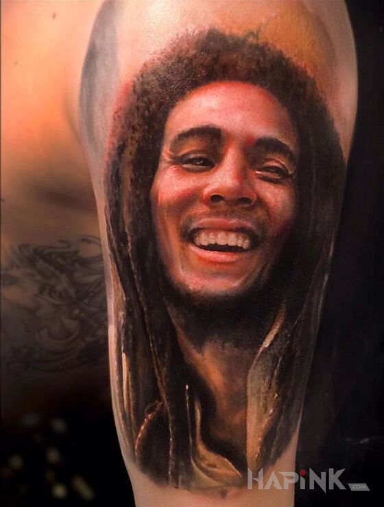 Tattoo Bob Marley in characters motif on the upper arm
