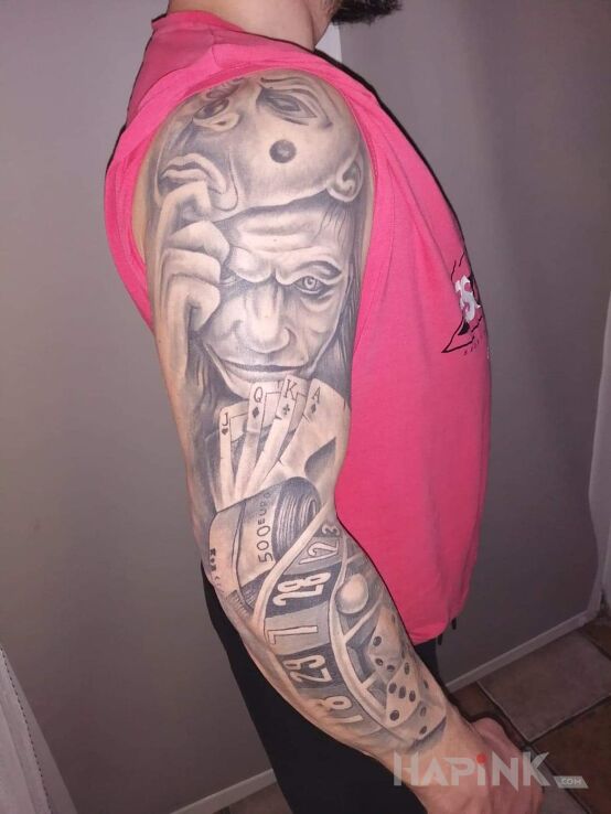 Tattoo Joker in sleeves motif and realistic style on the upper arm