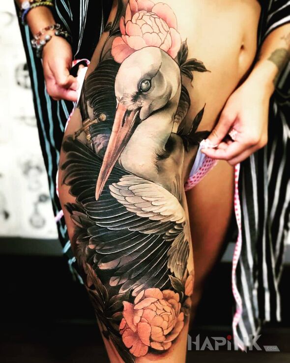 Tattoo Czy to bocian? in flowers motif and realistic style on the leg