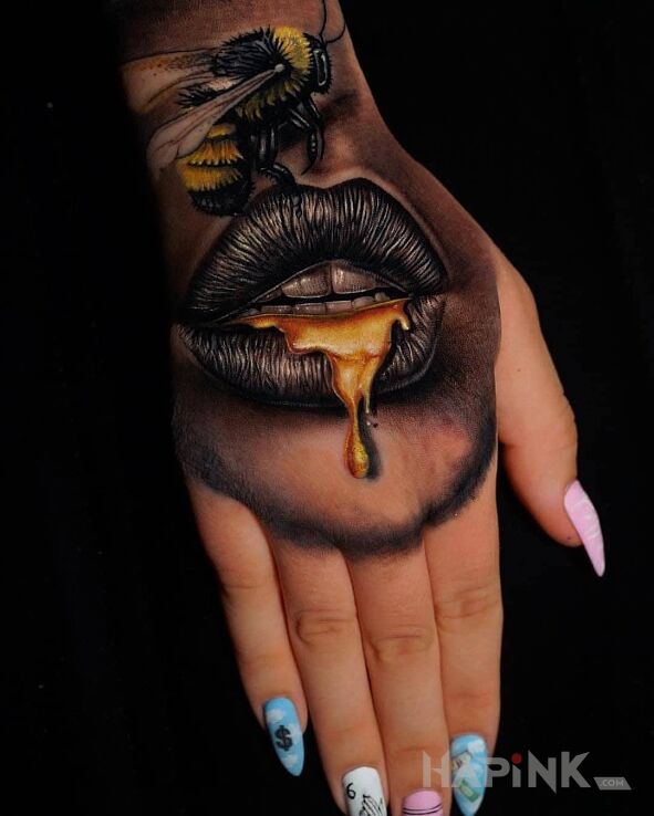 Tattoo Złote usta in colorful motif and realistic style on the hand