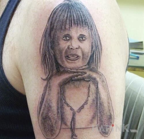 Tattoo Nieudany tattoo in faces motif on the upper arm