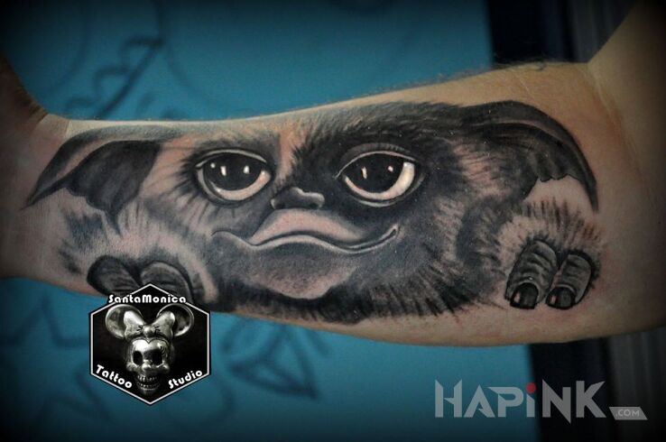 Tattoo Gizmo in black and gray motif and realistic style on the forearm