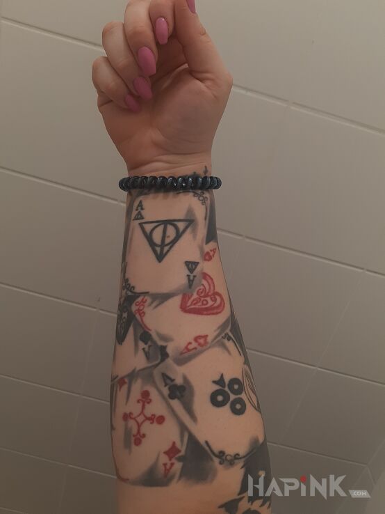 Tattoo Karty in objects motif and realistic style on the forearm