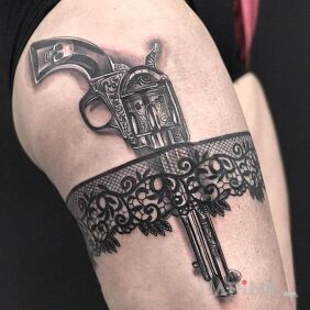 Tattoo Revolver on the leg motif: black and gray style: realistic