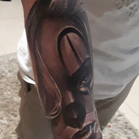 Tattoo Woman in a mask on the forearm motif: black and gray style: realistic