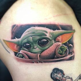 Tattoo Baby Joda on the upper arm motif: colorful style: realistic
