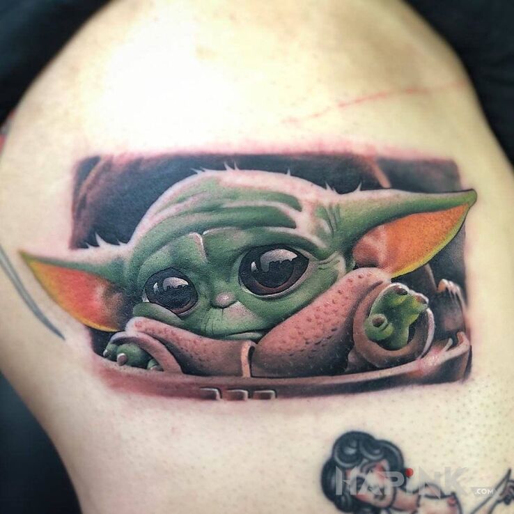 Tattoo Baby Joda in characters motif and realistic style on the upper arm