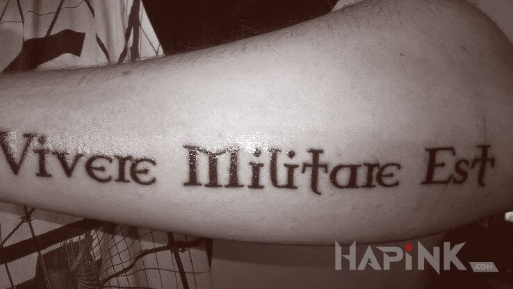 Tattoo Vivere militare est in lettering motif on the forearm
