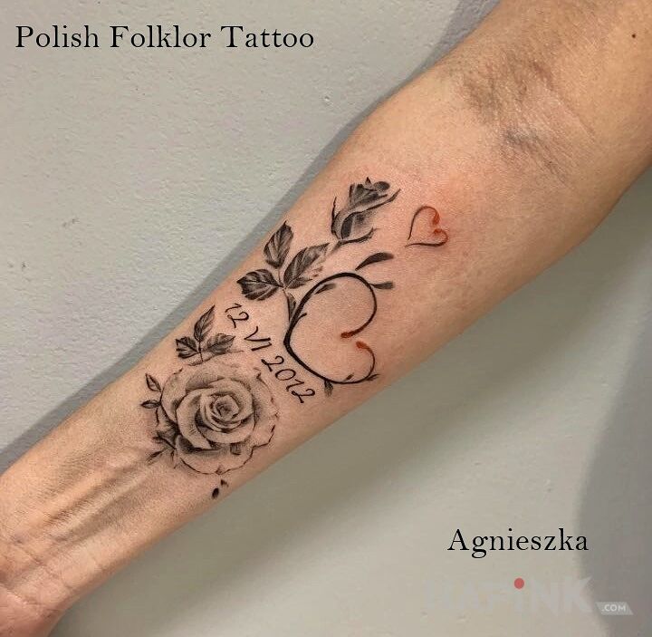 Tattoo Miłość in flowers motif and realistic style on the forearm