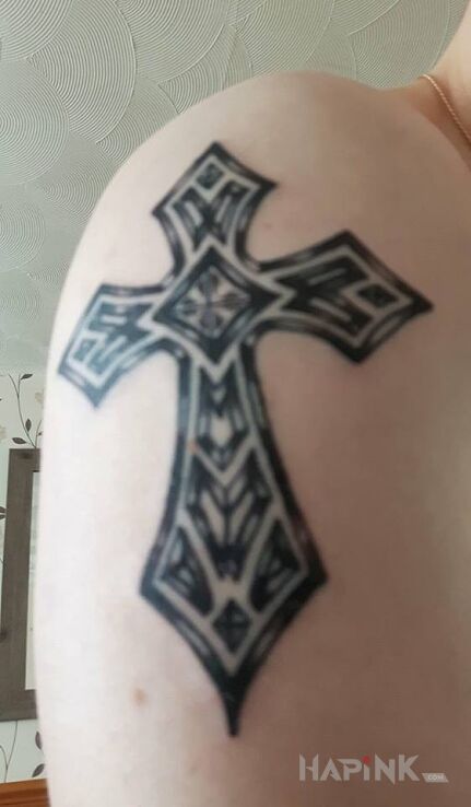 Tattoo Pierwszy : ) in religious motif on the upper arm