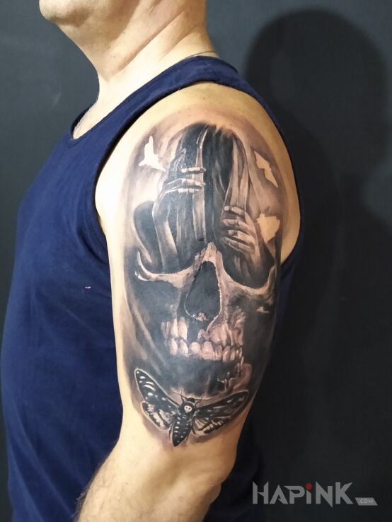 Tattoo Dziewczyna czaszka i ćma in skulls motif and realistic style on the upper arm
