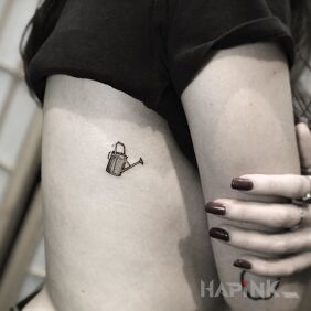 Tattoo Small watering can on the ribs motif: black and gray style: minimalistic