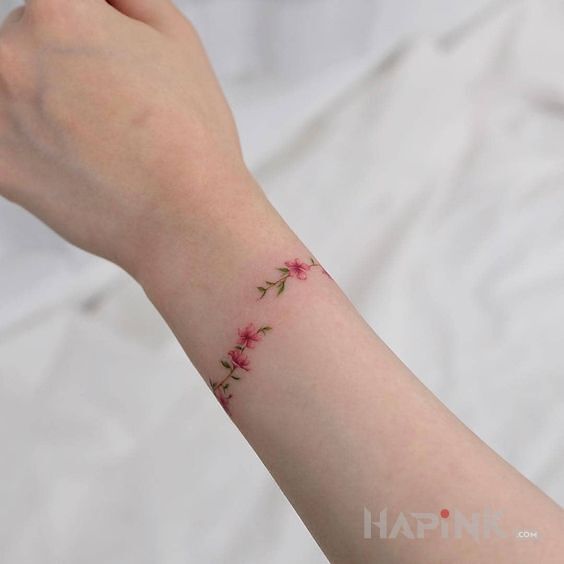 Tattoo Bransoletka z kwiatów in colorful motif and minimalistic style on the wrist