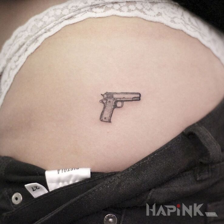 Tattoo Pistolecik in black and gray motif and minimalistic style on the buttocks