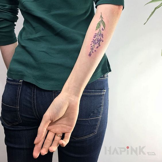 Tattoo Gałązka in flowers motif and realistic style on the forearm