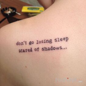 Tattoo Fear of shadows on the shoulder blades motif: lettering style: calligraphy