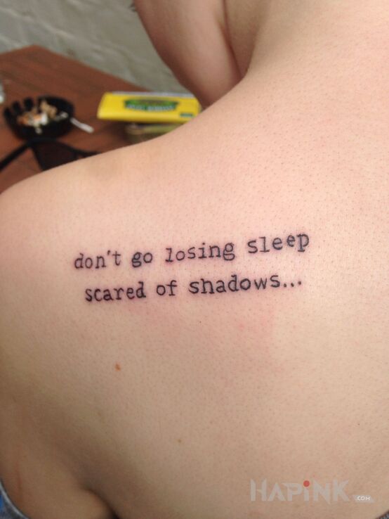 Tattoo Strach przed cieniami in lettering motif and calligraphy style on the shoulder blades