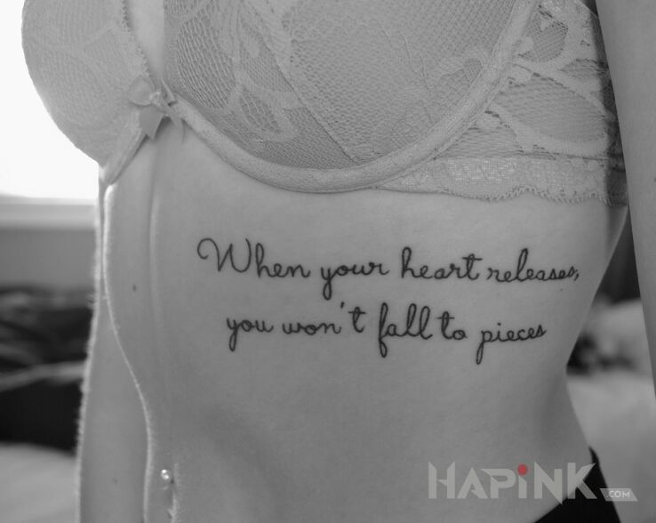 Tattoo Zwolnienie serca in lettering motif and calligraphy style on the ribs