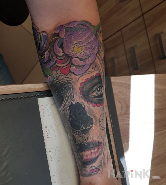 Tattoo Rozdarta Muerta in flowers motif and graphic / illustrative style on the forearm