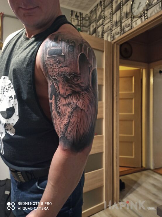 Tattoo Tatoo in black and gray motif and realistic style on the upper arm