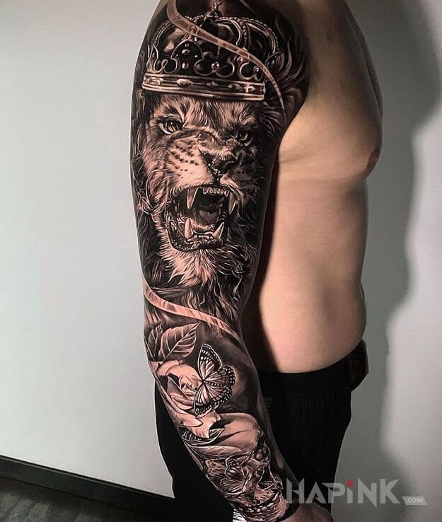 Tattoo Królewski lew in black and gray motif and realistic style on the upper arm