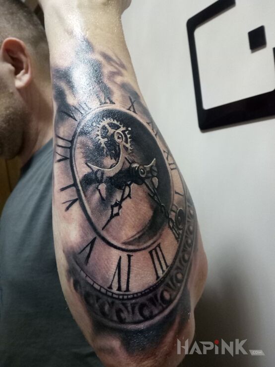Tattoo Zegar in black and gray motif and realistic style on the forearm