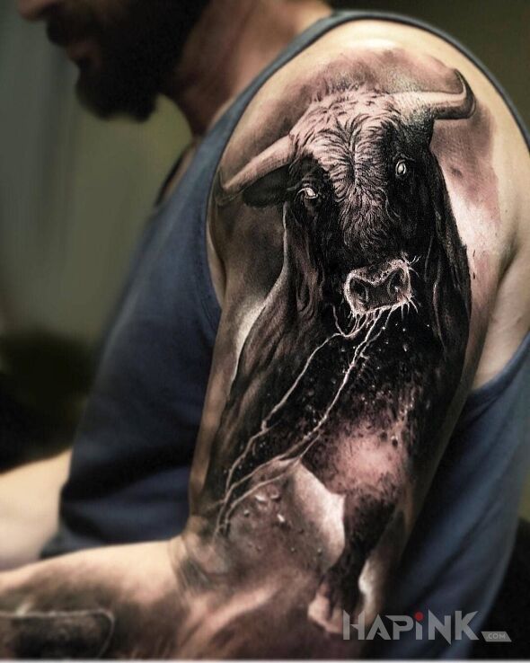 Tattoo Byku in zodiac signs motif and realistic style on the upper arm