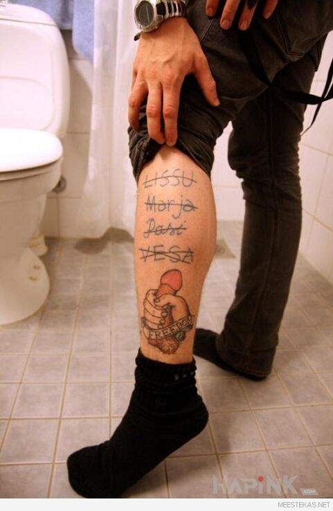 Tattoo Wolność :) in lettering motif on the leg