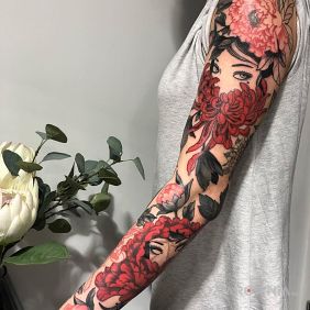 Tatuaż Kobiety za czerwonymi kwiatami na przedramieniu motyw: kwiaty styl: japońskie / irezumi