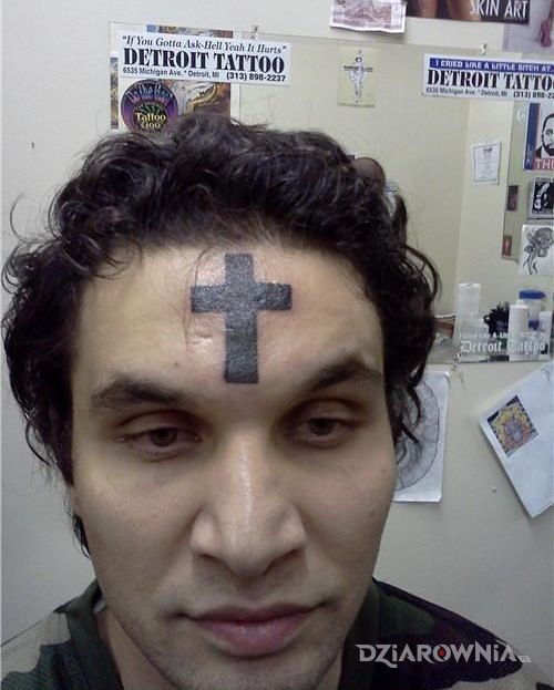 Tatuaż fanatyk w motywie religijne na twarzy