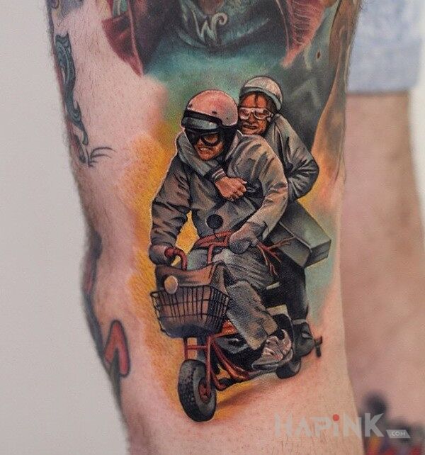 Tattoo Głupi i głupszy in characters motif on the upper arm