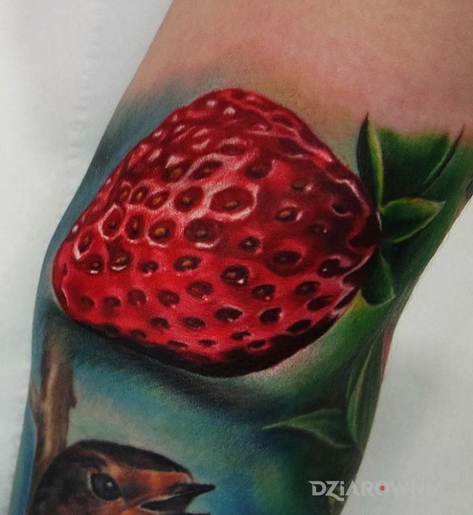 Tatuaż truskawa w motywie 3D na ramieniu