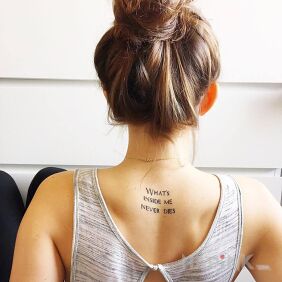 Tattoo What's inside me on the back motif: lettering style: calligraphy