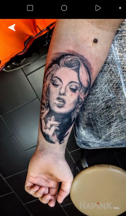 Tattoo Marilyn Monroe in black and gray motif and realistic style on the forearm