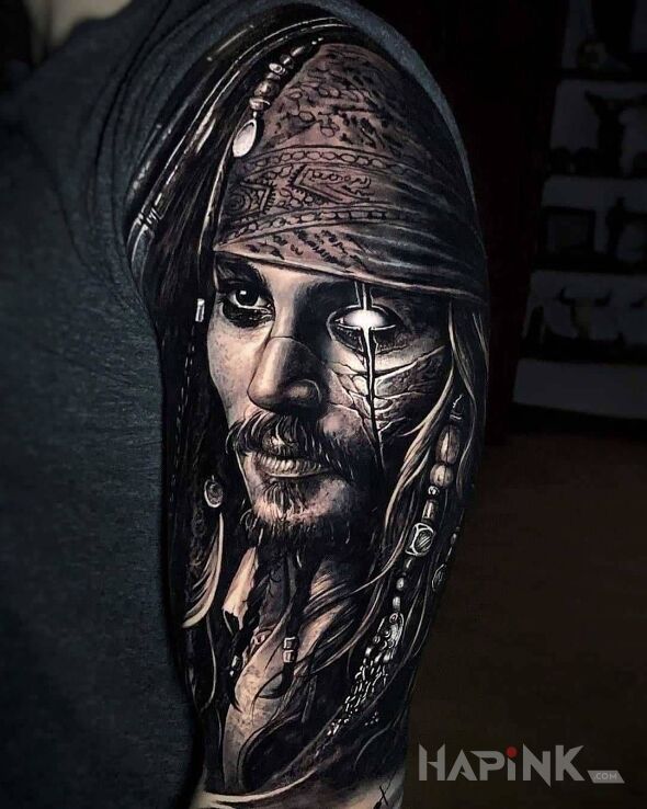 Tattoo Jack Saprrow in faces motif and realistic style on the upper arm