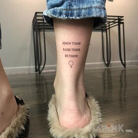 Tattoo Women on the leg motif: lettering style: calligraphy