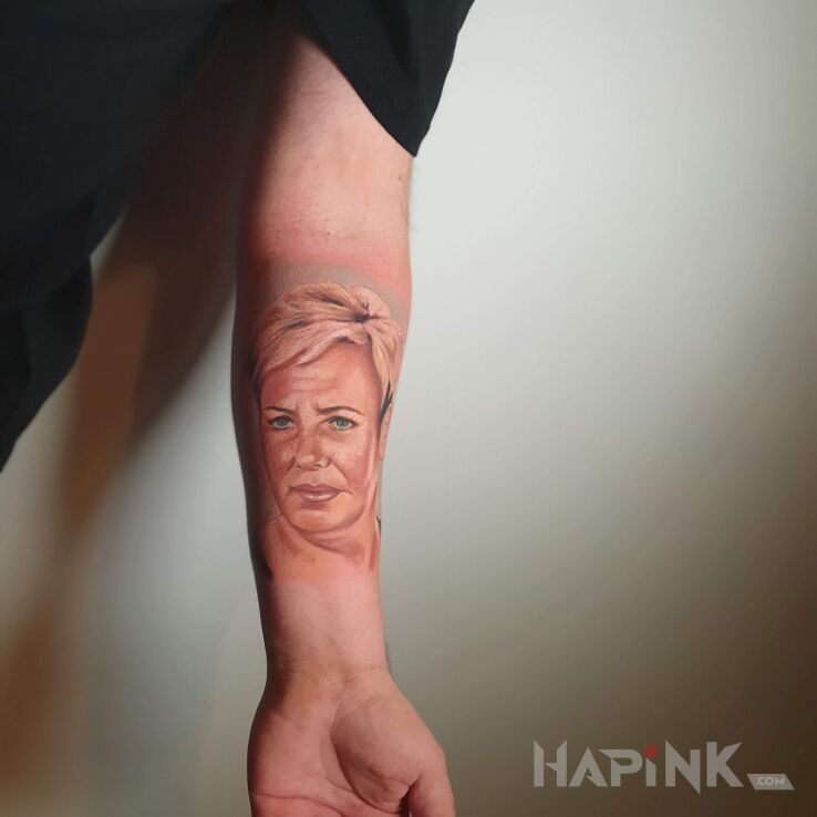 Tattoo Mama + in faces motif and realistic style on the forearm