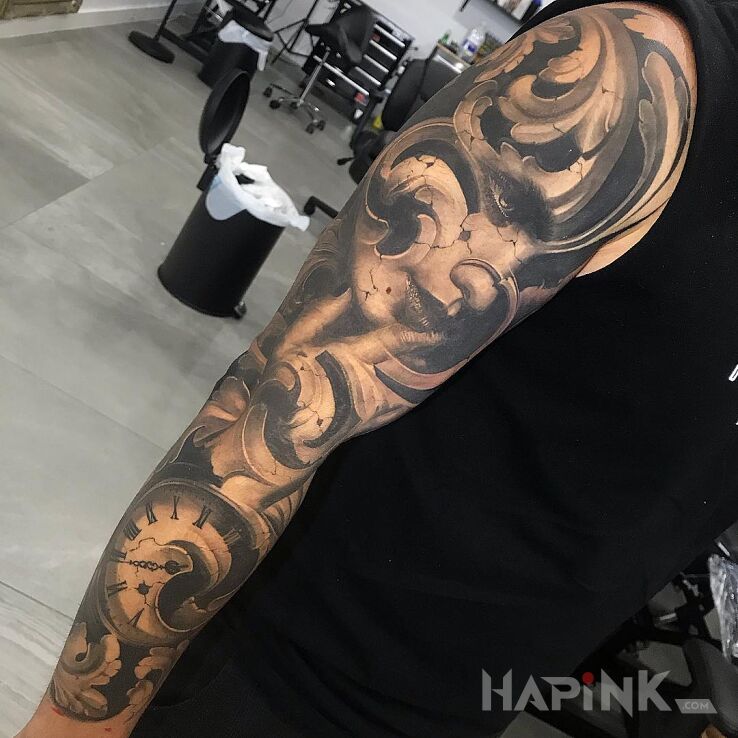 Tattoo Wyrzeźbiona twarz in faces motif and realistic style on the upper arm