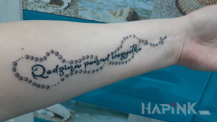 Tattoo Napis + różaniec in lettering motif and calligraphy style on the forearm