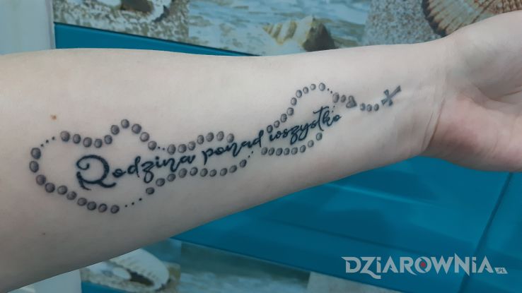 Tatuaż napis  różaniec w motywie napisy i stylu kaligrafia na przedramieniu