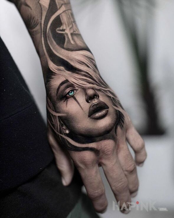 Tattoo Twarzyczka in black and gray motif and realistic style on the hand