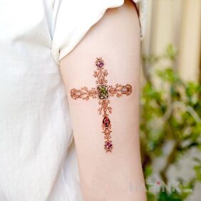 Tattoo Cross on the upper arm motif: religious style: realistic