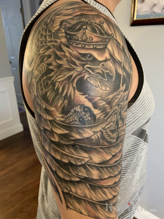 Tattoo Polski Ozel in black and gray motif and graphic / illustrative style on the upper arm