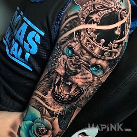 Tattoo The crowned lion on the upper arm motif: flowers style: realistic