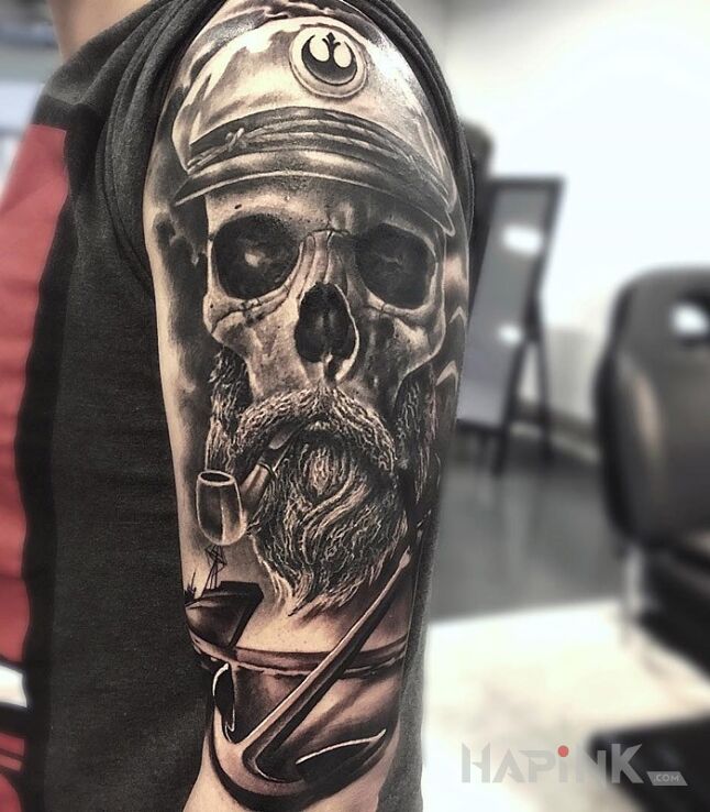 Tattoo Kapitan in skulls motif on the upper arm