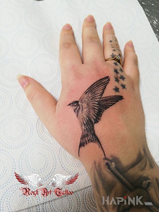 Tattoo Ptaszek in black and gray motif and realistic style on the hand