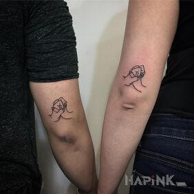 Tattoo By the hands on the upper arm motif: Love style: minimalistic