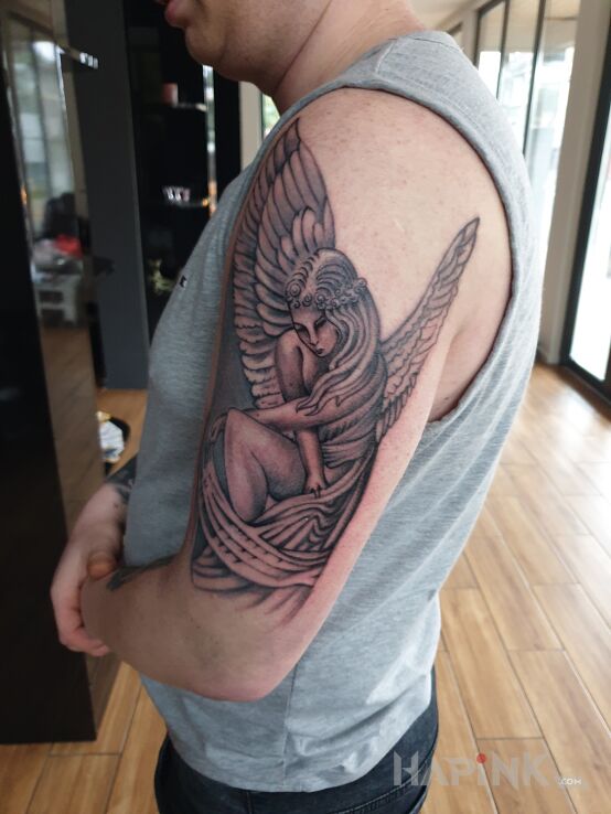Tattoo Anioł in black and gray motif on the upper arm